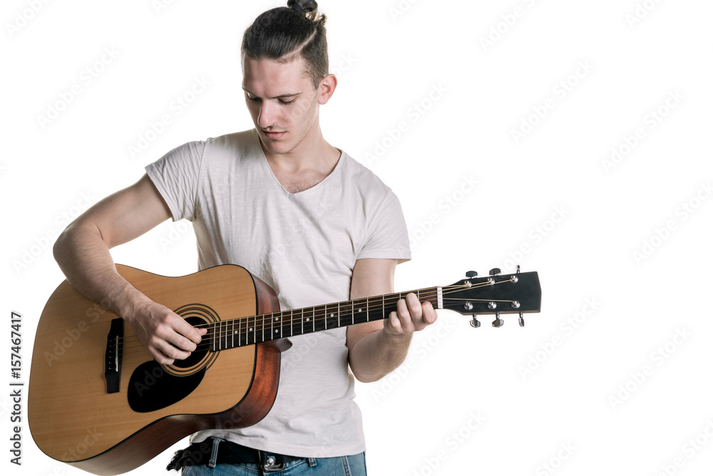 Obraz premium Music and creativity. Handsome young man in t-shirt playing on acoustic guitar. Horizontal frame