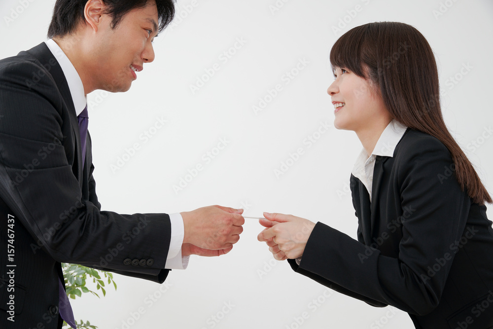 名刺交換をするビジネスウーマンとビジネスマン