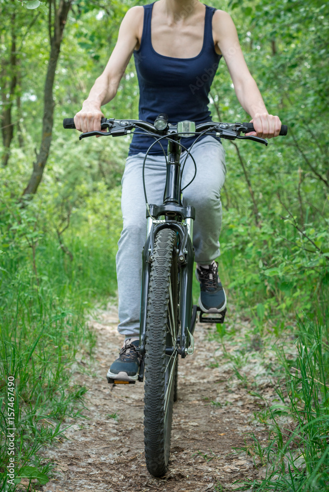 Naklejka premium A trip on a mountain bike along the forest path. Sports and the concept of active life in the summer. Vertical frame
