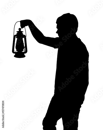Silhouette of teenage boy holding up lantern