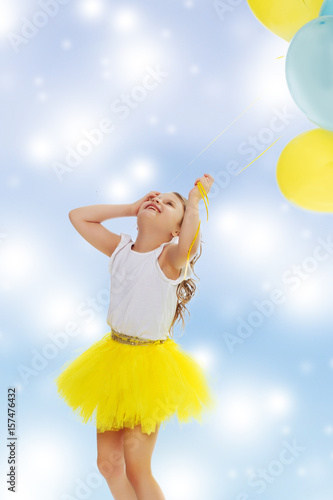 Little girl with balloons in his hands .
