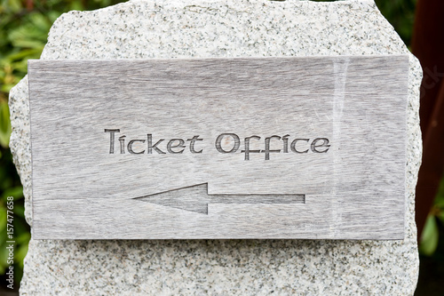 Text ticket office with arrow on wooden panel