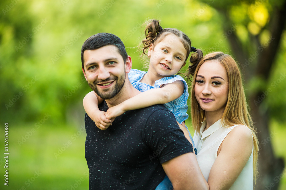 Happy joyful young family father, mother and little daughter having fun outdoors, playing together in summer park, countryside. Happy joyful young family father, mother and little daughter having fun outdoors, playing together in summer park, countryside.