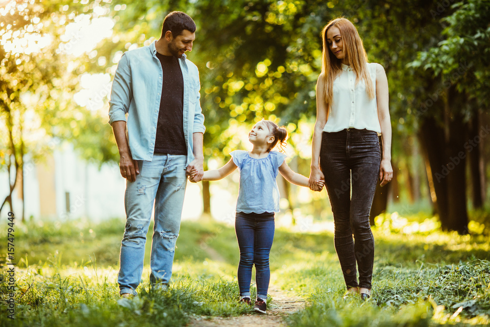 young family on a walk in the summer park young family on a walk in the summer park