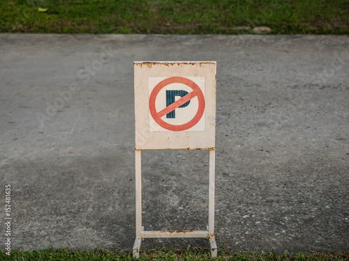 Old don't parking sign with rust stand on a road. 