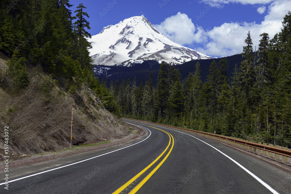 Fototapeta premium Snow covered Mount Hood, a volcano in the Cascade Mountains in Oregon popular for hiking, climbing, snowboarding and skiing, despite the risks of avalanche, crevasses and volatile weather on the peak.