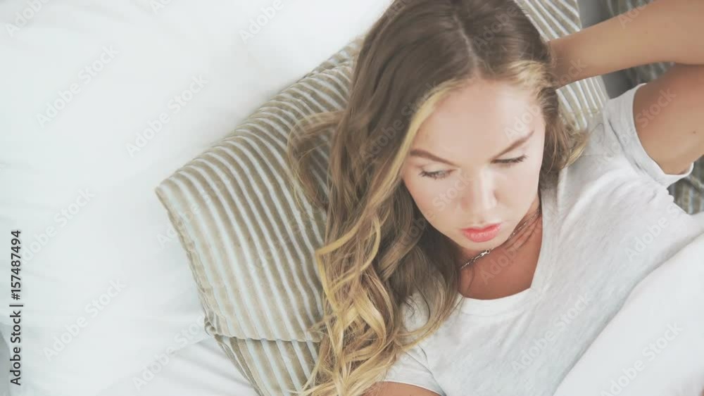 Earlier in the morning: beautiful girl is sleeping and waking up. Young girl is sleeping with her hair and wakes up. Sweet blonde wakes up and stretches. Woman in pajamas in bed and wakes up Earlier in the morning: beautiful girl is sleeping and waking up. Young girl is sleeping with her hair and wakes up. Sweet blonde wakes up and stretches. Woman in pajamas in bed and wakes up