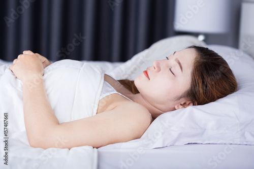 Woman sleeping on bed in bedroom