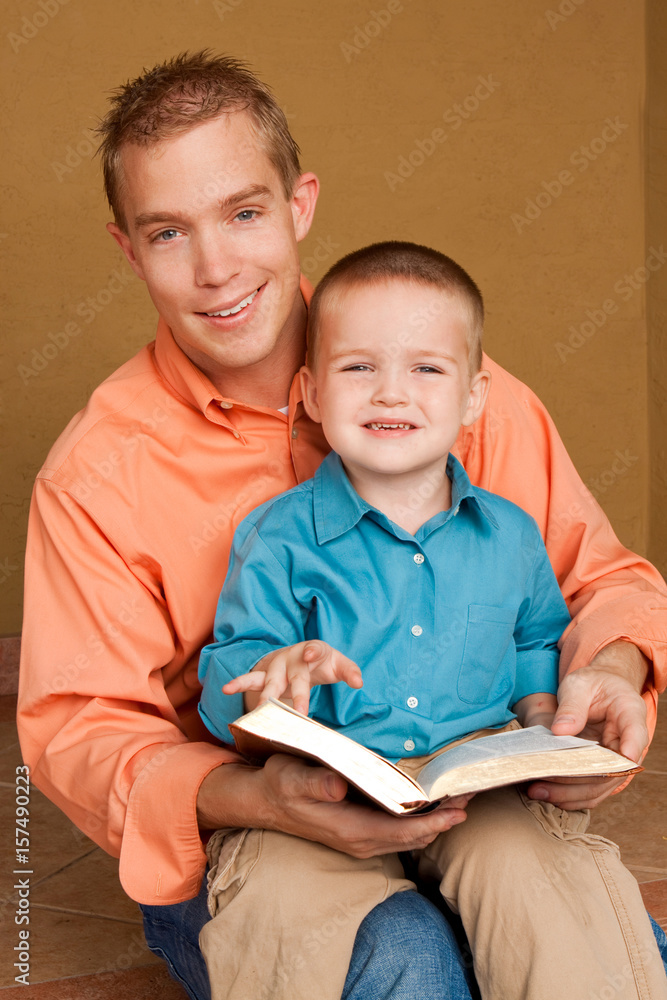 Happy loving father reading with his son.