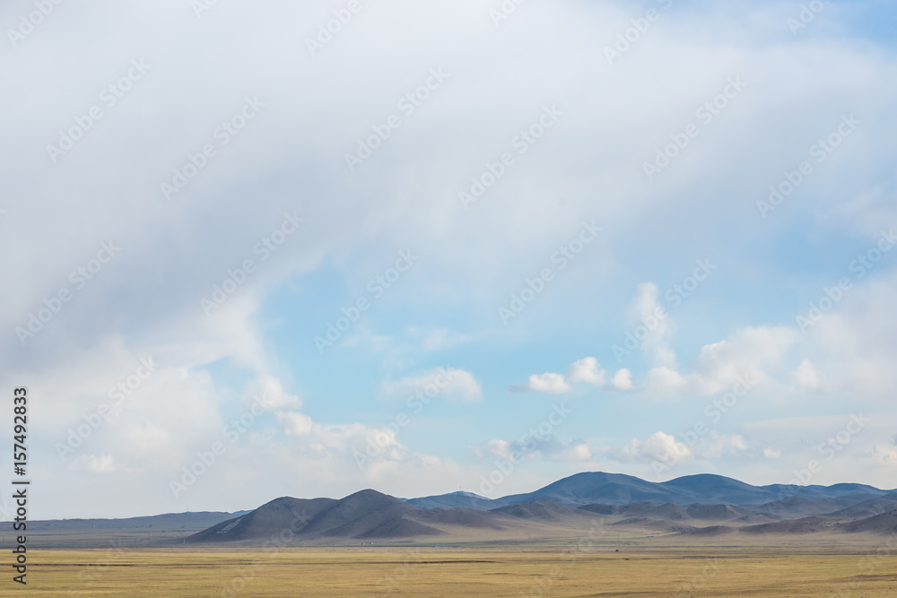 panoramic view of snow-capped mongolian prairie with cloudy sky on background
