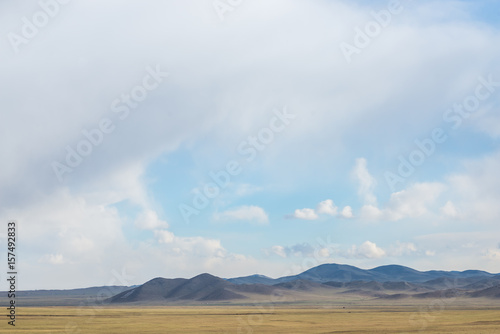 panoramic view of snow-capped mongolian prairie with cloudy sky on background 