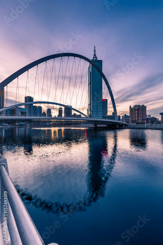 Downtown City skyline along the River at twilight in Tianjin China.