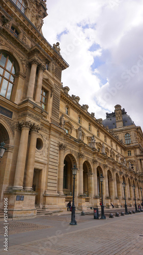 Photo of iconic Louvre Palace on a cloudy spring morning  Paris  France