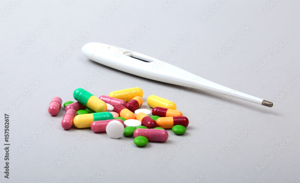 Pills and medical thermometer on white background. . Pills and medical thermometer on white background. .