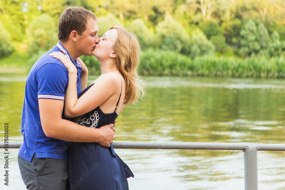 summer holidays, love, romance and people concept - happy smiling young couple hugging outdoors summer holidays, love, romance and people concept - happy smiling young couple hugging outdoors