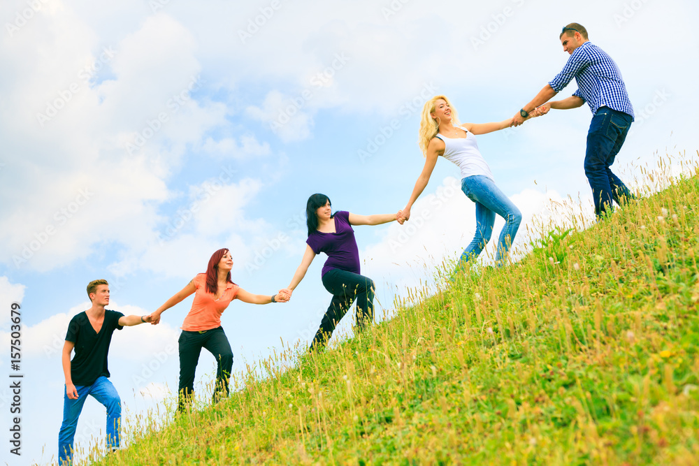 Young People Helping Each Other Climb A Hill Young People Helping Each Other Climb A Hill