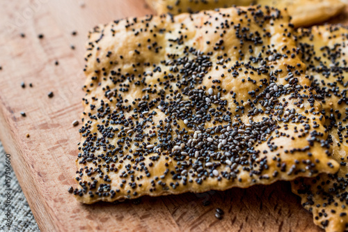Crispbread with chia seeds and sesame on wooden surface.