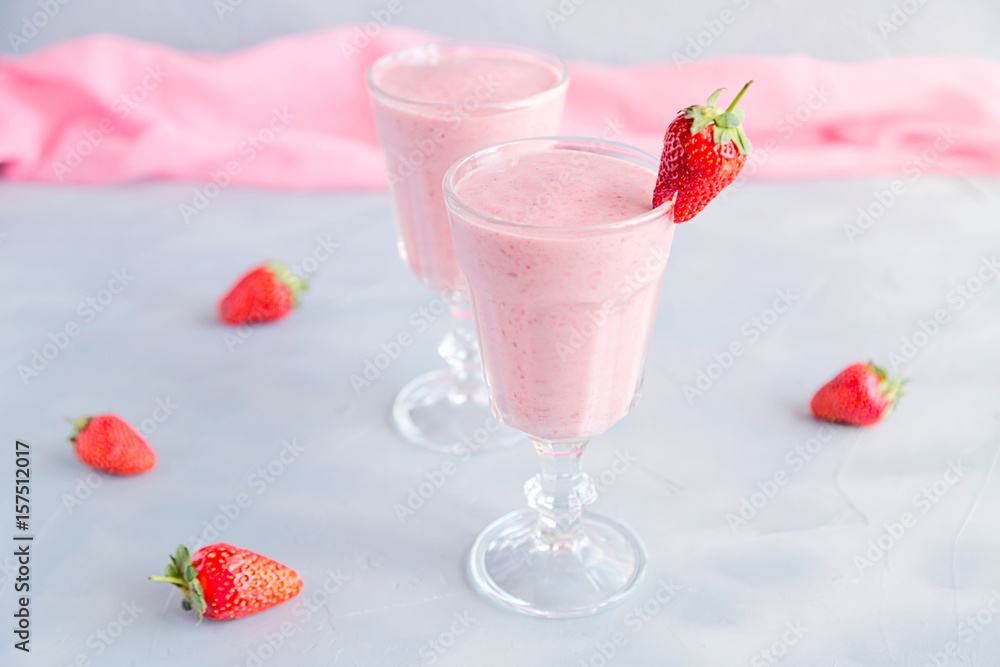 Fresh and Cold Strawberry Smoothie in Tall Glasses on Grey Background Fresh and Cold Strawberry Smoothie in Tall Glasses on Grey Background