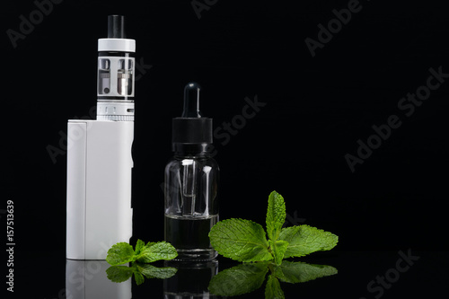 Mint flavor for an electronic cigarette with reflection on a black background photo