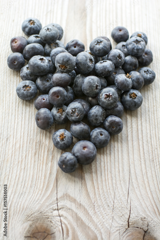 Blueberries in form of heart are on the wooden background Blueberries in form of heart are on the wooden background