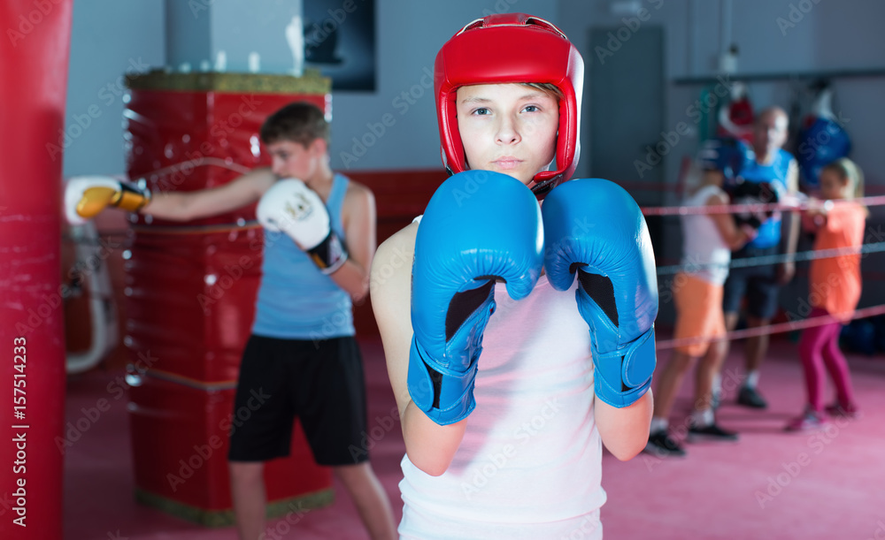 Teenage boy boxer posing during boxing exercising