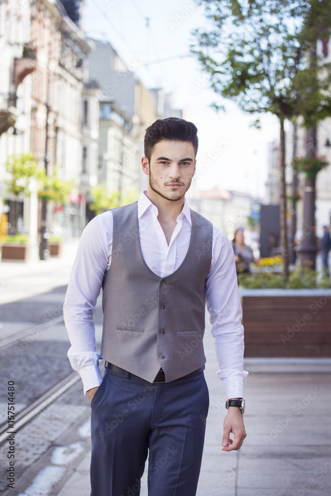 Young handsome businessman dressed smartly, walking through the city