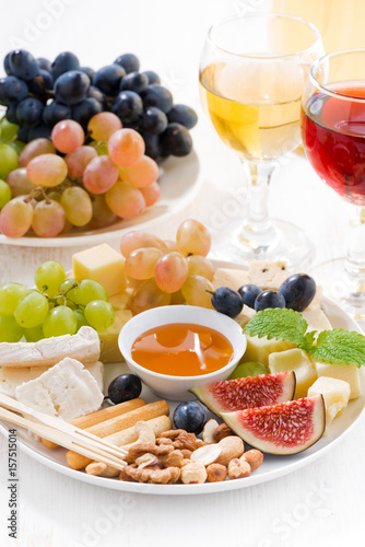 cheeses, fruits, wine and snacks, closeup vertical