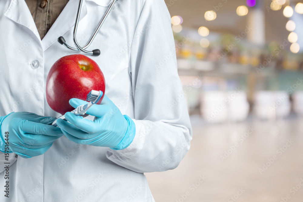 dentist holding a ripe apple dentist holding a ripe apple