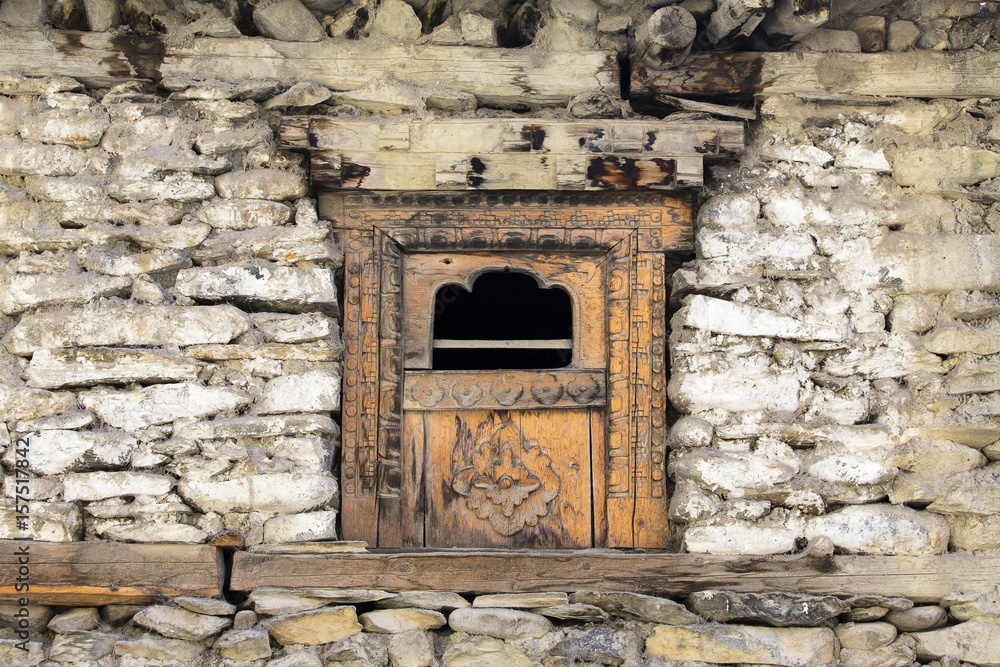 Wooden windows in an old stone wall in the village of Manang, Himalayas, Nepal . Wooden windows in an old stone wall in the village of Manang, Himalayas, Nepal .