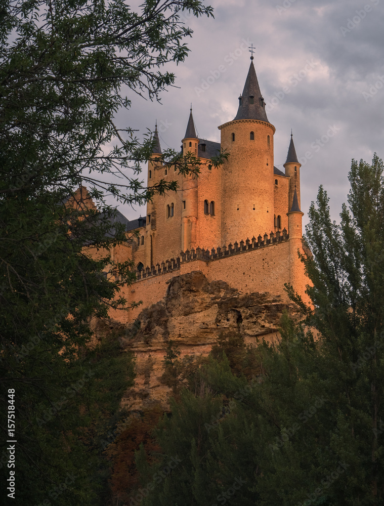 fondo historico del famoso castillo , Alcazar de Segovia, España, junto a un bosque de arboles frondosos