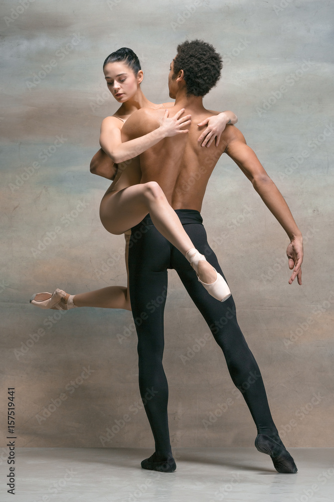 Couple of ballet dancers posing over gray background Couple of ballet dancers posing over gray background