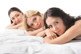 young beautiful women looking at camera while lying on bed