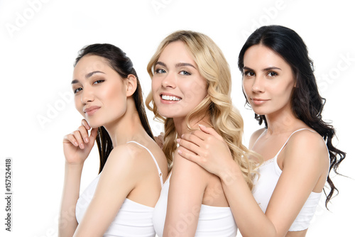 group of smiling women in lingerie posing isolated on white