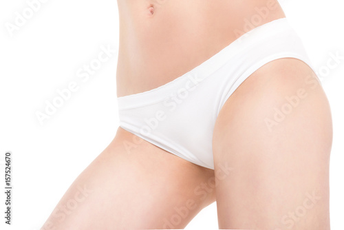 Close-up partial view of slim young woman posing in panties isolated on white
