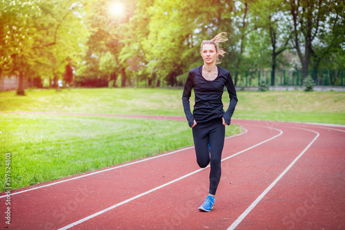 Athletic woman running on track, healthy lifestyle