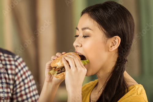 portrait of young asian girl eating tasty burger