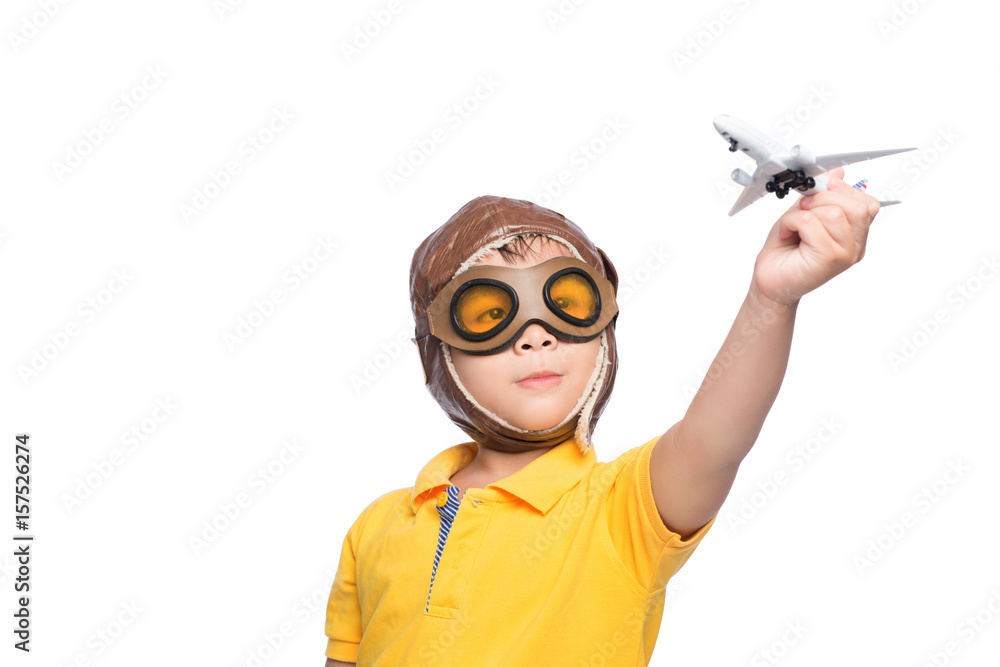 Beautiful smiling child boy in helmet on a white background playing with a plane. Beautiful smiling child boy in helmet on a white background playing with a plane.