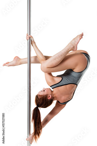 Strong and beautiful girl posing on a pylon on a white background