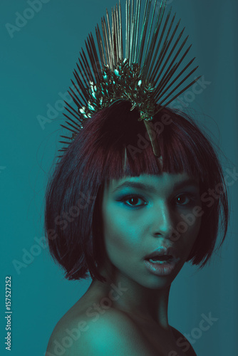portrait of young astonished african american woman in stylish headpiece