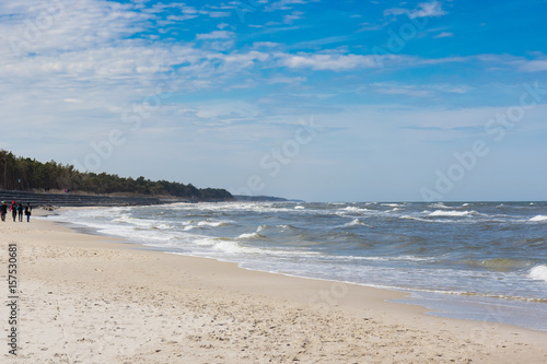 Spacer plażą nad Morzem Bałtyckim w wietrzny, wiosenny dzień