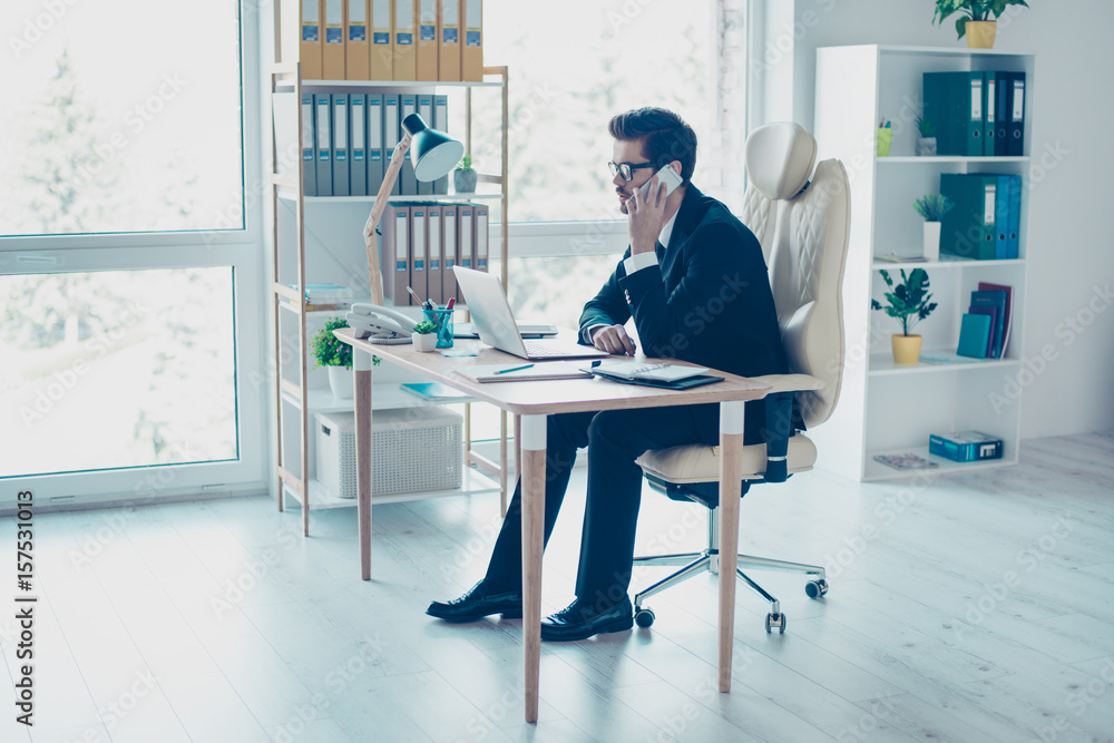 Busy minded businessman sitting at office and making a call to his business partners Busy minded businessman sitting at office and making a call to his business partners
