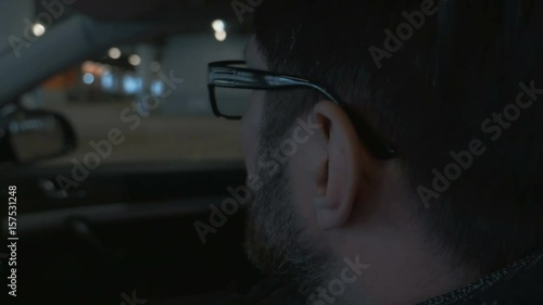 A man driving the car at undergroung parking. Close up. Bokeh background photo