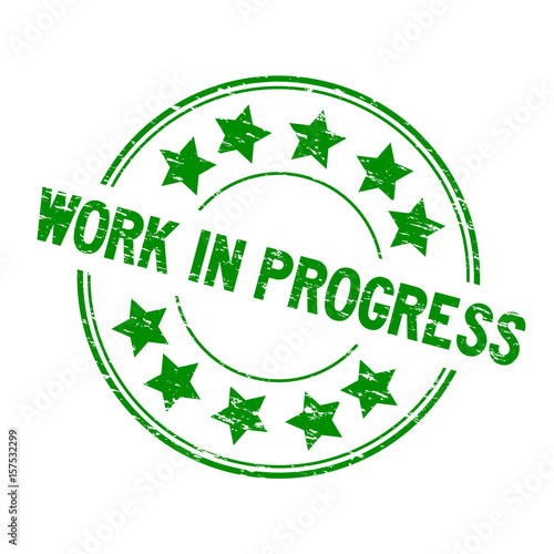 Grunge green work in process with star icon round rubber seal stamp on white background