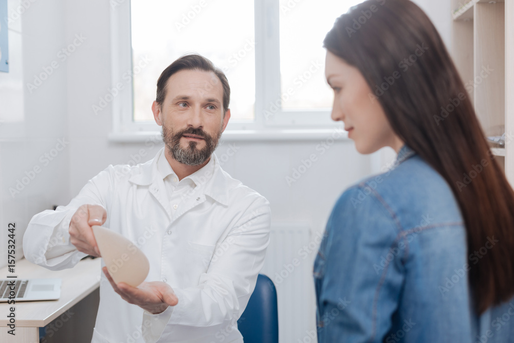 Successful advanced plastic surgeon consulting his client Successful advanced plastic surgeon consulting his client