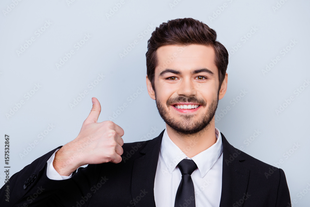 Close up photo of young smart man showing thumb up by recommending his way of running business Close up photo of young smart man showing thumb up by recommending his way of running business