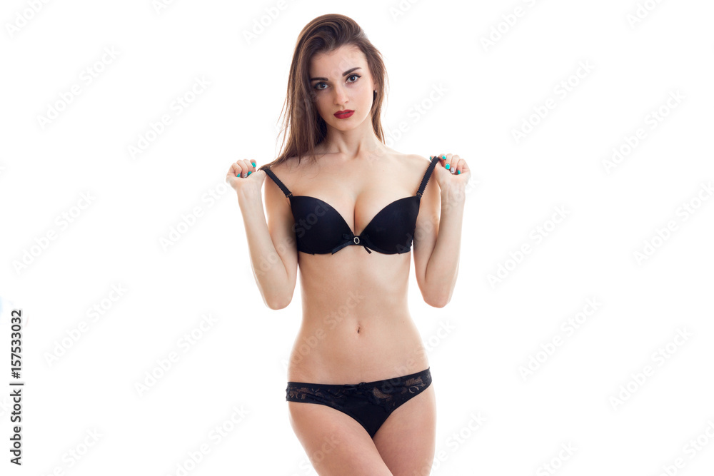 sexy young girl with red lipstick and black lingerie stands in front of the  camera and holds the hands bra straps Stock Photo | Adobe Stock