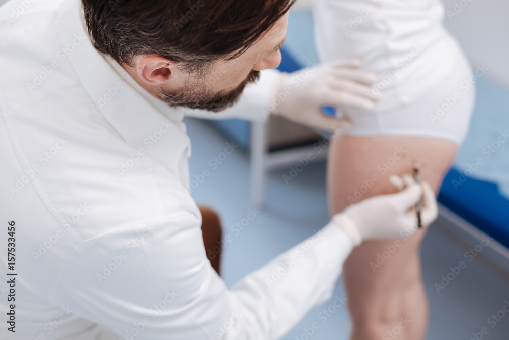 Fototapeta premium Competent caring doctor helping his patient feeling beautiful