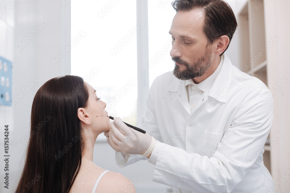 Hardworking caring plastic surgeon ensuring preciseness Hardworking caring plastic surgeon ensuring preciseness