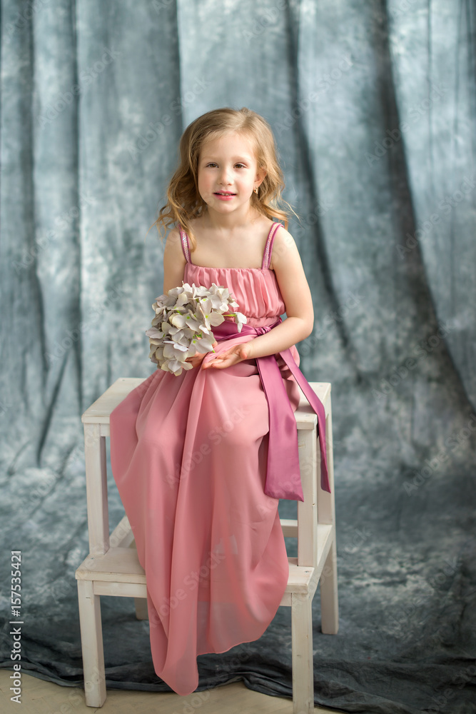 The little girl 5-6 years at the grey photofon background. Portrait photostudio The little girl 5-6 years at the grey photofon background. Portrait photostudio