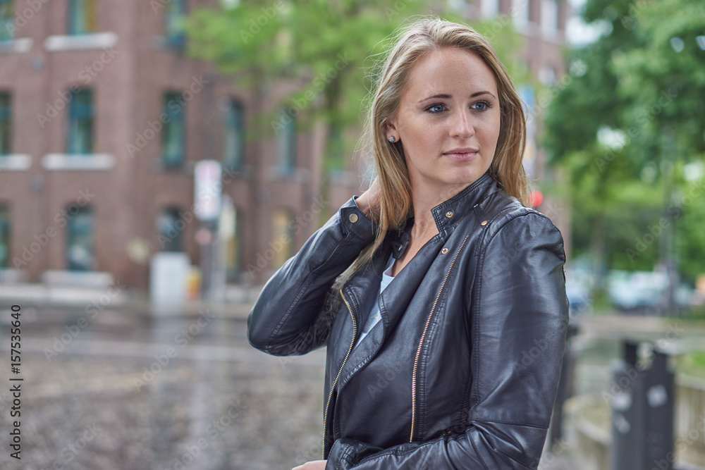 Fototapeta premium Frau mit Lederjacke im Regen in Stadt